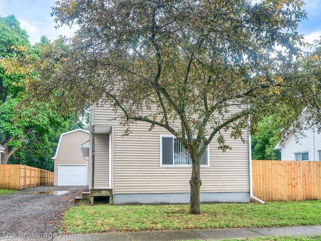 658 Beach St, Mount Morris, MI 48458 - view of home's exterior with a detached garage and an outbuilding