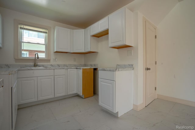 163 Moss St, Highland Park, MI 48203 - kitchen with light marble finish flooring, light countertops, and white cabinets