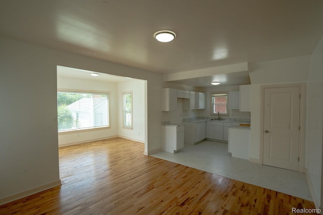163 Moss St, Highland Park, MI 48203 - kitchen featuring white cabinetry, light wood-style flooring, plenty of natural light, and light countertops