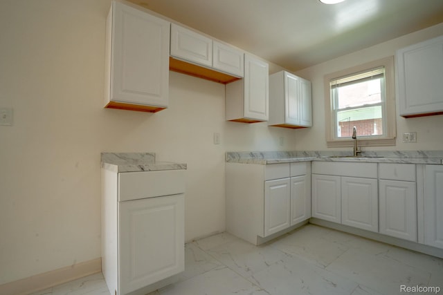 163 Moss St, Highland Park, MI 48203 - kitchen with light marble finish flooring, white cabinetry, and light countertops