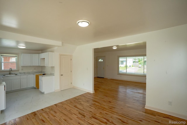 163 Moss St, Highland Park, MI 48203 - kitchen featuring open floor plan, white cabinetry, light wood-type flooring, and light countertops