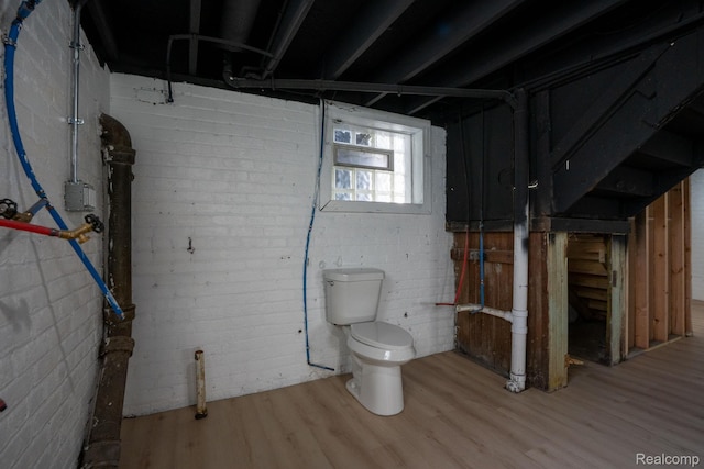 163 Moss St, Highland Park, MI 48203 - below grade area featuring wood finished floors and brick wall