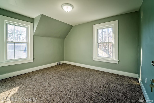 959 Washtenaw Rd, Ypsilanti, MI 48197 - additional living space with dark colored carpet and vaulted ceiling