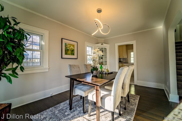 959 Washtenaw Rd, Ypsilanti, MI 48197 - dining space featuring stairway, dark wood-style flooring, crown molding, a chandelier, and arched walkways