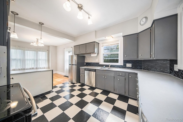 2904 Maplewood Ave, Ann Arbor, MI 48104 - kitchen with appliances with stainless steel finishes, gray cabinetry, light floors, and decorative backsplash