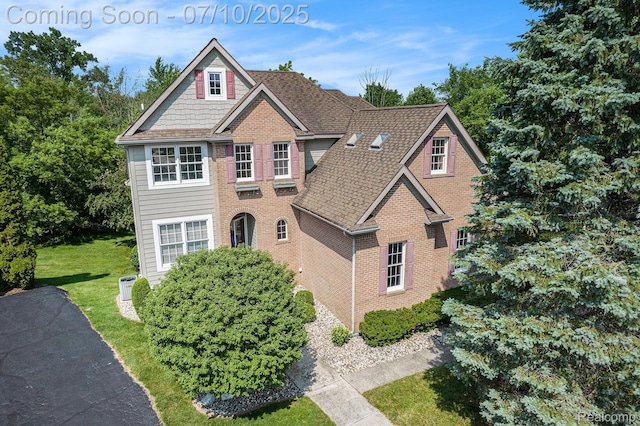 6161 Golfside Ct, Grand Blanc, MI 48439 - view of front facade featuring brick siding, a front lawn, and a shingled roof