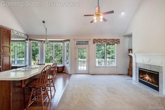 6161 Golfside Ct, Grand Blanc, MI 48439 - dining space with ceiling fan, high vaulted ceiling, a tile fireplace, light colored carpet, and recessed lighting
