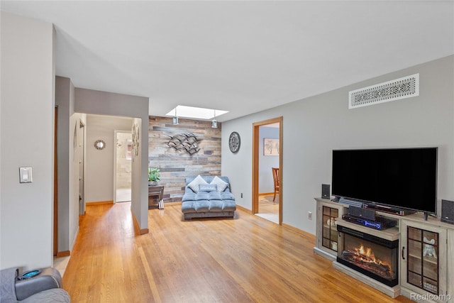 26714 Dover Ct, Warren, MI 48089 - living room with wood finished floors, wooden walls, an accent wall, and a glass covered fireplace