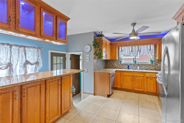 26714 Dover Ct, Warren, MI 48089 - kitchen featuring stainless steel appliances, light stone counters, tasteful backsplash, brown cabinets, and a ceiling fan