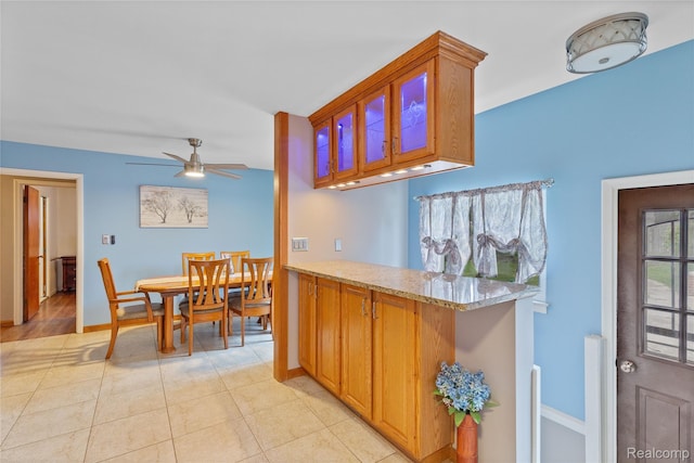 26714 Dover Ct, Warren, MI 48089 - kitchen with ceiling fan, brown cabinets, light tile patterned floors, and light stone countertops