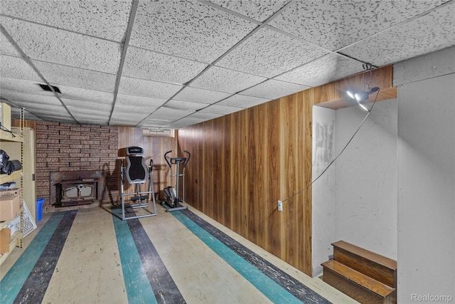 26714 Dover Ct, Warren, MI 48089 - exercise room featuring a wood stove, wood finished floors, wooden walls, and a paneled ceiling