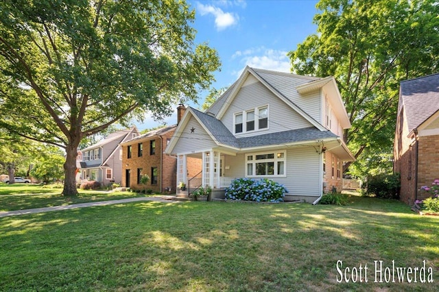 702 Griswold St SE, Grand Rapids, MI 49507 - view of front of house featuring a front lawn, a chimney, a shingled roof, and brick siding
