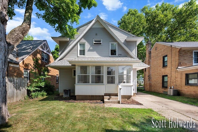 702 Griswold St SE, Grand Rapids, MI 49507 - view of front facade featuring a front lawn, roof with shingles, and a sunroom