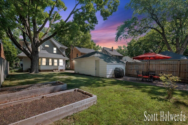 702 Griswold St SE, Grand Rapids, MI 49507 - fenced backyard with a vegetable garden, a patio, and a storage shed