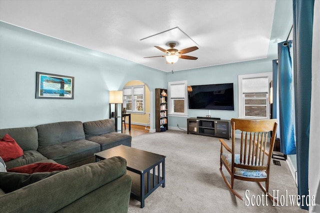 702 Griswold St SE, Grand Rapids, MI 49507 - living room with arched walkways, ceiling fan, light colored carpet, and plenty of natural light