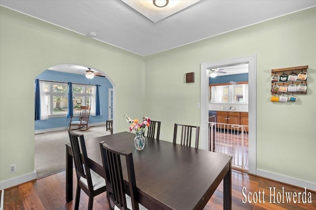 702 Griswold St SE, Grand Rapids, MI 49507 - dining space featuring arched walkways, ceiling fan, and wood finished floors