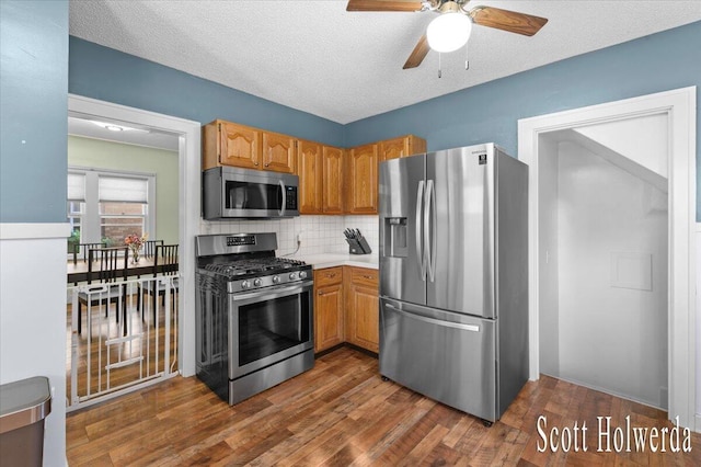 702 Griswold St SE, Grand Rapids, MI 49507 - kitchen featuring appliances with stainless steel finishes, a ceiling fan, backsplash, light countertops, and dark wood finished floors