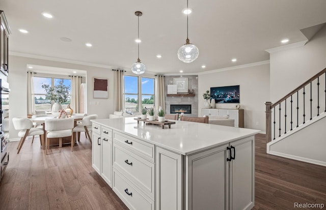 49937 Kent Ct, Canton, MI 48188 - kitchen with a glass covered fireplace, ornamental molding, dark wood-style floors, healthy amount of natural light, and recessed lighting