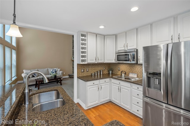 31085 Chatsford St, Novi, MI 48377 - kitchen with stainless steel appliances, white cabinets, decorative backsplash, recessed lighting, and decorative light fixtures
