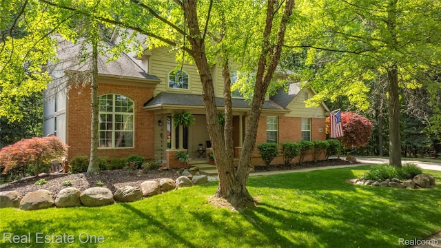 31085 Chatsford St, Novi, MI 48377 - traditional-style house featuring brick siding, a front yard, and a shingled roof