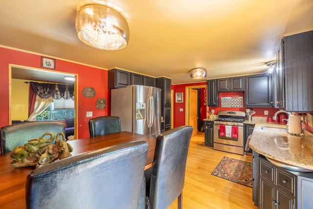19744 Ivey Rd, Chelsea, MI 48118 - kitchen featuring appliances with stainless steel finishes, light wood-style flooring, light stone countertops, and ornamental molding