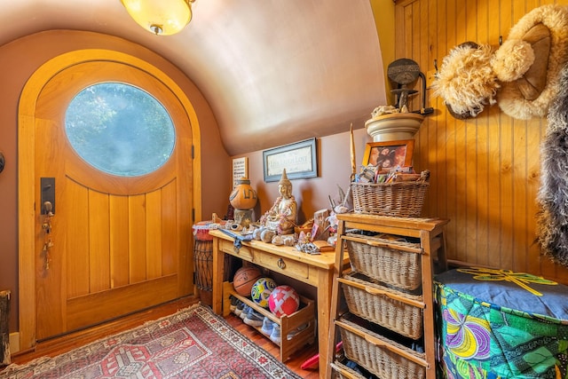 19744 Ivey Rd, Chelsea, MI 48118 - foyer featuring vaulted ceiling, wood finished floors, and wood walls