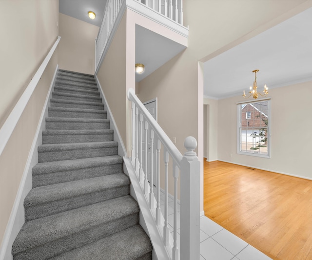 668 Boston Ct, Ann Arbor, MI 48103 - stairs with a chandelier, tile patterned flooring, and ornamental molding