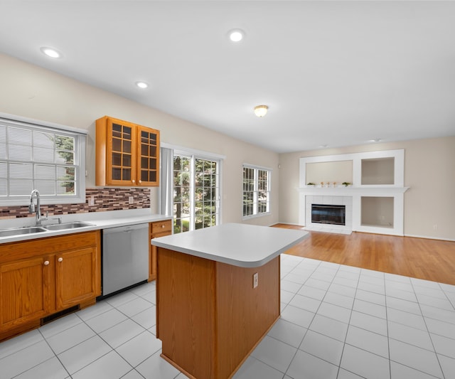 668 Boston Ct, Ann Arbor, MI 48103 - kitchen featuring stainless steel dishwasher, a fireplace, light countertops, a center island, and glass insert cabinets