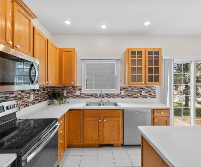 668 Boston Ct, Ann Arbor, MI 48103 - kitchen with stainless steel appliances, tasteful backsplash, glass insert cabinets, light countertops, and recessed lighting