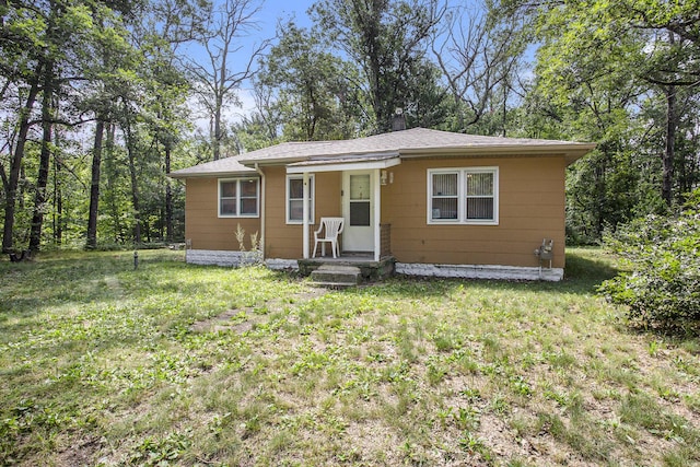 565 E Rockford Rd, Idlewild, MI 49642 - bungalow featuring a front lawn and roof with shingles