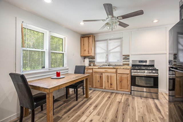 565 E Rockford Rd, Idlewild, MI 49642 - kitchen featuring stainless steel gas range, plenty of natural light, light wood-style floors, ceiling fan, and recessed lighting