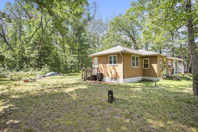 565 E Rockford Rd, Idlewild, MI 49642 - view of side of home featuring a lawn and a shingled roof