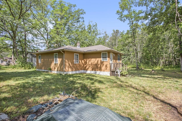 565 E Rockford Rd, Idlewild, MI 49642 - view of side of property featuring a chimney, a yard, and roof with shingles