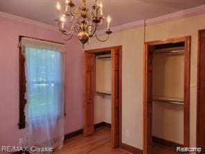 17951 Prospect St, Dearborn Heights, MI 48122 - unfurnished bedroom with a chandelier, ornamental molding, and light wood-type flooring