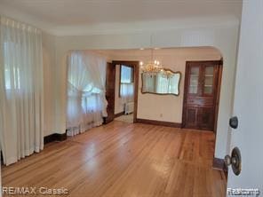 17951 Prospect St, Dearborn Heights, MI 48122 - unfurnished dining area featuring arched walkways, light wood finished floors, and a chandelier