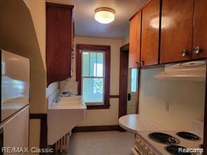 17951 Prospect St, Dearborn Heights, MI 48122 - kitchen with brown cabinets, extractor fan, range, and light countertops