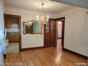 17951 Prospect St, Dearborn Heights, MI 48122 - unfurnished dining area featuring light wood-style floors and a chandelier
