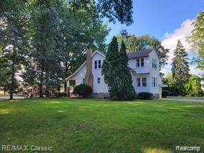 17951 Prospect St, Dearborn Heights, MI 48122 - view of front of house with a front yard and a chimney