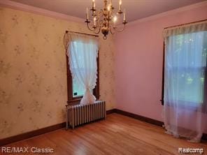 17951 Prospect St, Dearborn Heights, MI 48122 - spare room with radiator heating unit, a chandelier, wood finished floors, healthy amount of natural light, and crown molding