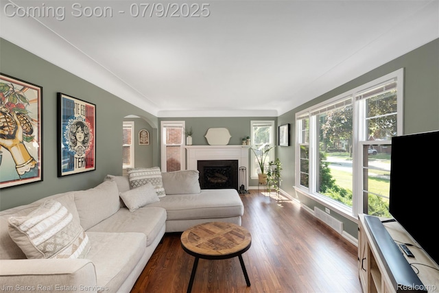 2182 Hawthorne Rd, Detroit, MI 48236 - living room featuring dark wood-style flooring, arched walkways, and a fireplace with flush hearth