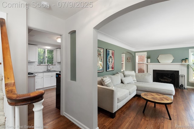 2182 Hawthorne Rd, Detroit, MI 48236 - living room with arched walkways, dark wood-style flooring, and a fireplace with flush hearth
