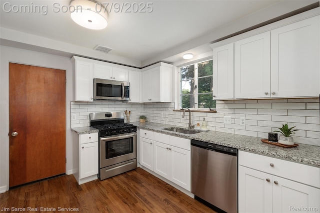 2182 Hawthorne Rd, Detroit, MI 48236 - kitchen featuring stainless steel appliances, dark wood-style flooring, backsplash, and light stone counters