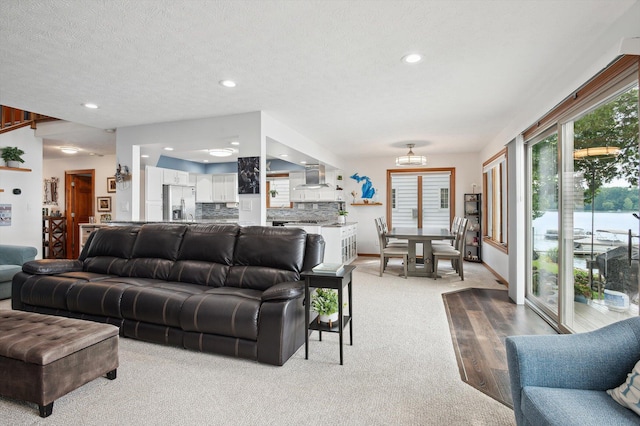 5090 Schrah Dr, Munith, MI 49259 - living room with light colored carpet, recessed lighting, a chandelier, and a textured ceiling