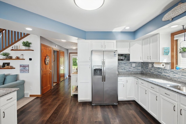 5090 Schrah Dr, Munith, MI 49259 - kitchen featuring stainless steel refrigerator with ice dispenser, black microwave, tasteful backsplash, dark wood finished floors, and white cabinets