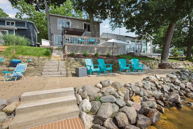 5090 Schrah Dr, Munith, MI 49259 - rear view of property with a wooden deck, stairs, and a patio