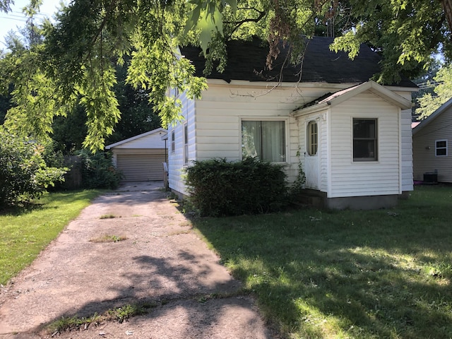 1483 Rose Ave, Benton Harbor, MI 49022 - view of front facade with a front yard, an outdoor structure, a garage, and roof with shingles