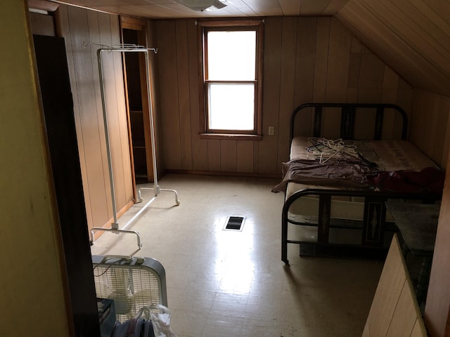 1483 Rose Ave, Benton Harbor, MI 49022 - bedroom featuring lofted ceiling, wooden walls, and light flooring