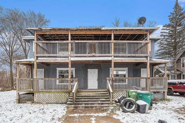 174 Cherry St, Battle Creek, MI 49017 - view of front of house with stucco siding, a porch, and a balcony