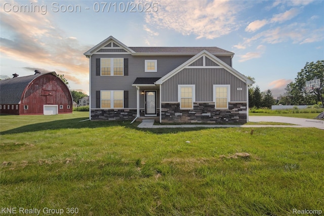 7057 Primrose Ln, Grand Blanc, MI 48439 - view of front of house featuring a barn, stone siding, board and batten siding, a yard, and an outbuilding
