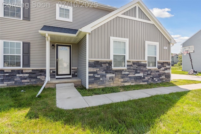 7057 Primrose Ln, Grand Blanc, MI 48439 - view of front of property featuring stone siding, board and batten siding, and a front yard